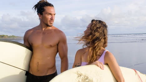 young couple with surfboards