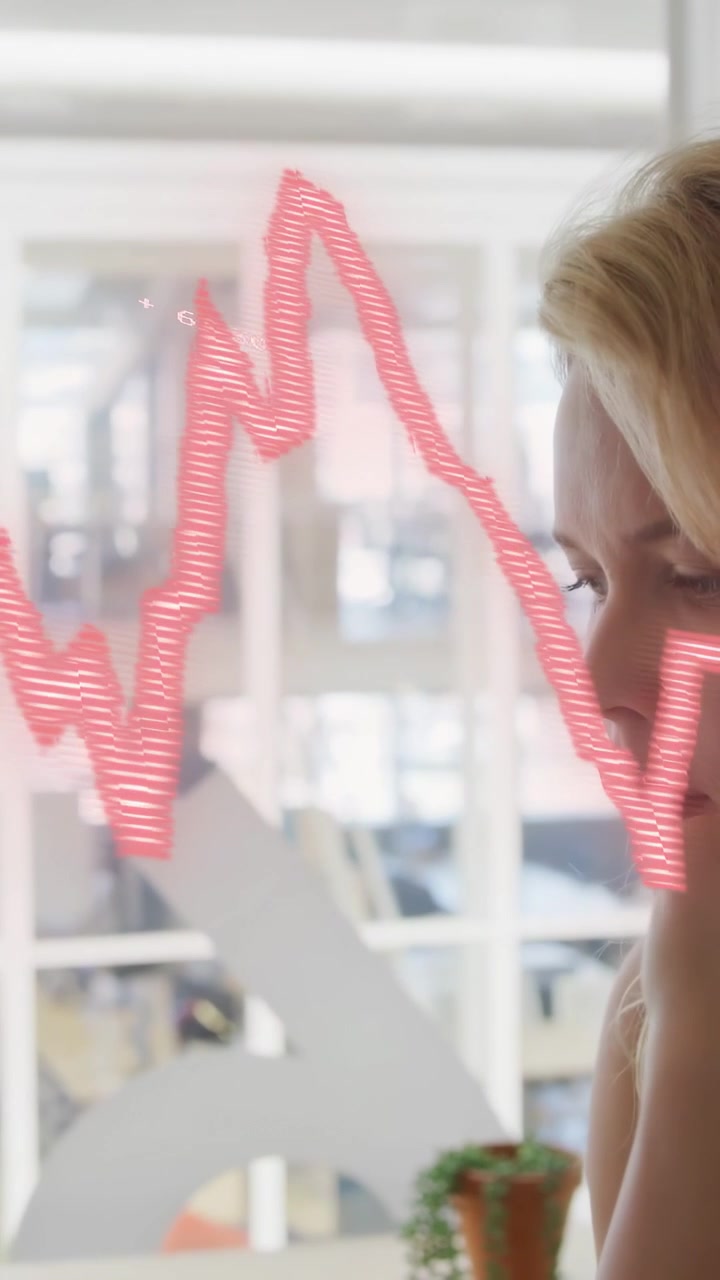 Vertical video: Office worker viewing data update, red wave moving across glass causing quiet pause
