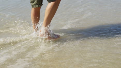 Hombre-Caminando-En-El-Agua-En-La-Playa-En-Un-Día-Soleado-4k