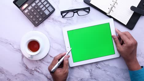 young man working on digital tablet with green screen