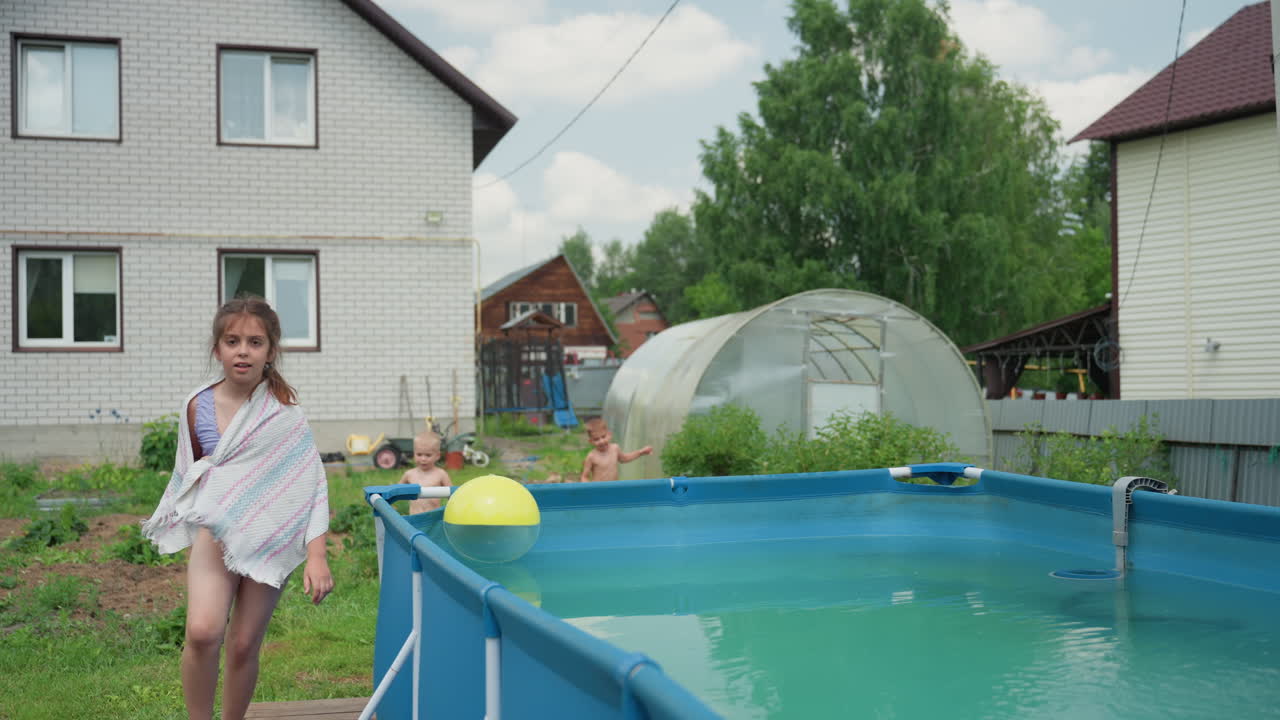 Serene Scene Of Girl Near Garden Pool, Peaceful Backyard With Girl Relaxing Before Swimming In Sunlight, Tranquil Outdoor Setting With Girl Wrapped In Towel Beside Small Pool And Lush Garden