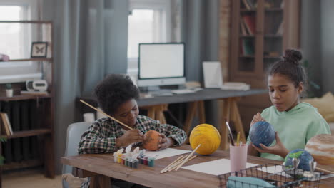afro kids making diy globe models