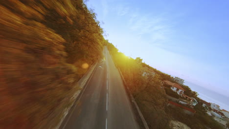 dynamic aerial drone footage of a person riding a motorcycle at sunrise. exciting action tracking shot with volumetric light beaming through the sky.
