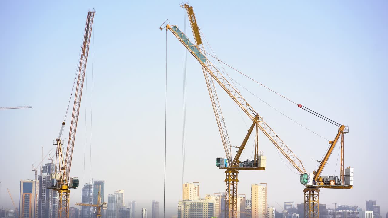 Tower Cranes Operating at Construction Site in Urban Skyline