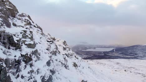 Wild-frozen-mountainous-slope-in-the-nordic-landscape-of-Hemavan-Tarnaby,-Sweden---Aerial-low-angle-fly-by