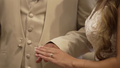 close up of bride placing wedding ring on groom's finger during their marriage ceremony