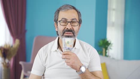 손에 돈 있는 중년 남자가 사려 깊다.