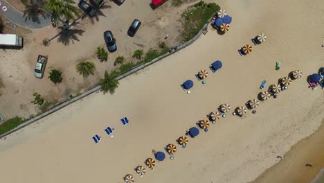 las imágenes aéreas capturan una serena playa de phuket con sombrillas y sillas, mostrando una vibrante atmósfera costera bajo un cielo despejado