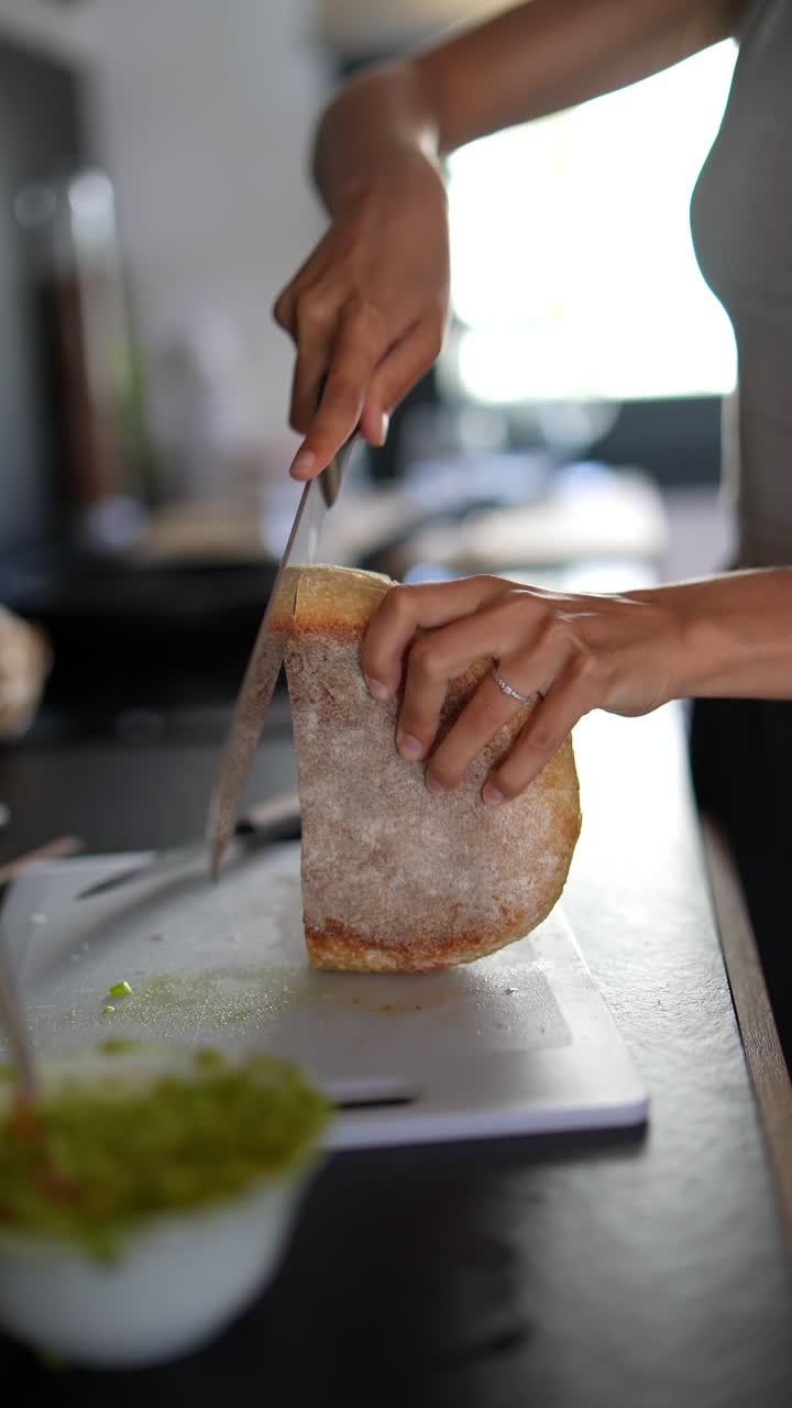 Woman Cutting Bread in Kitchen