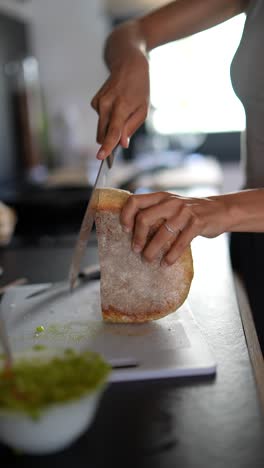 woman cutting bread in kitchen