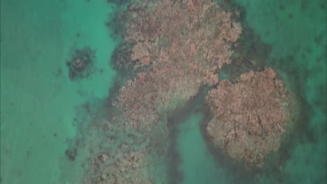 Flying-over-small-island-with-blue-water-in-Dominican-Republic