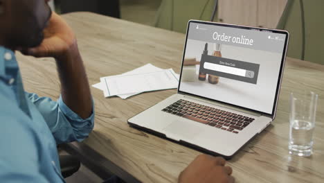 hombre afroamericano usando una computadora portátil, compras en línea de productos de belleza, cámara lenta