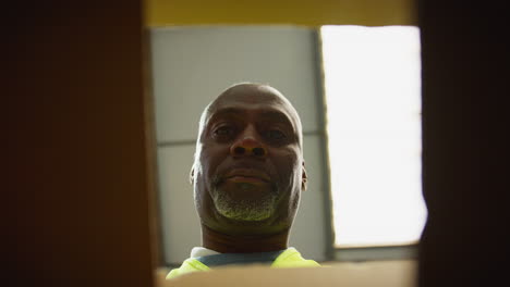 point of view shot of male worker in distribution warehouse closing and sealing box