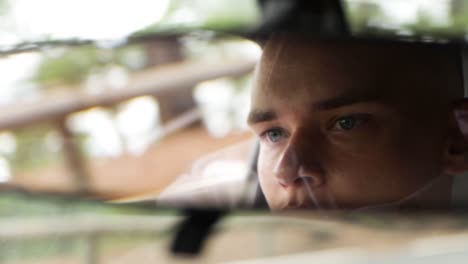 young man is driving a car