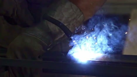 close-up of a welder at work with bright sparks and smoke