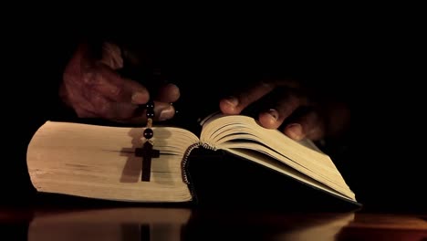 hombre rezando a dios con las manos junto con la biblia hombre caribeño rezando con fondo negro almacen de video