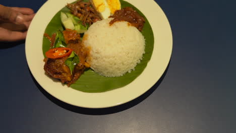 one men holing rice plate on table