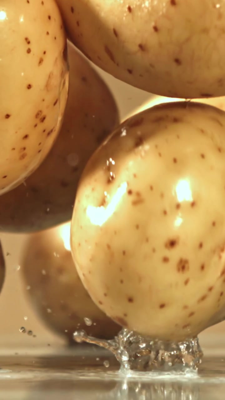 Patate fresche che cadono nell'acqua al rallentatore