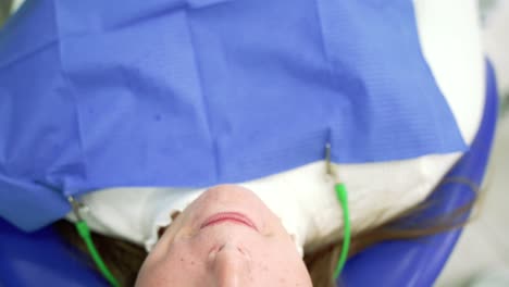 Anonymous dentist removing a woman&#039;s lip retractor in dental chair