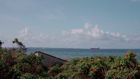 Bote-De-Remos-En-La-Costa-Con-Barco-En-El-Horizonte-En-Cámara-Lenta