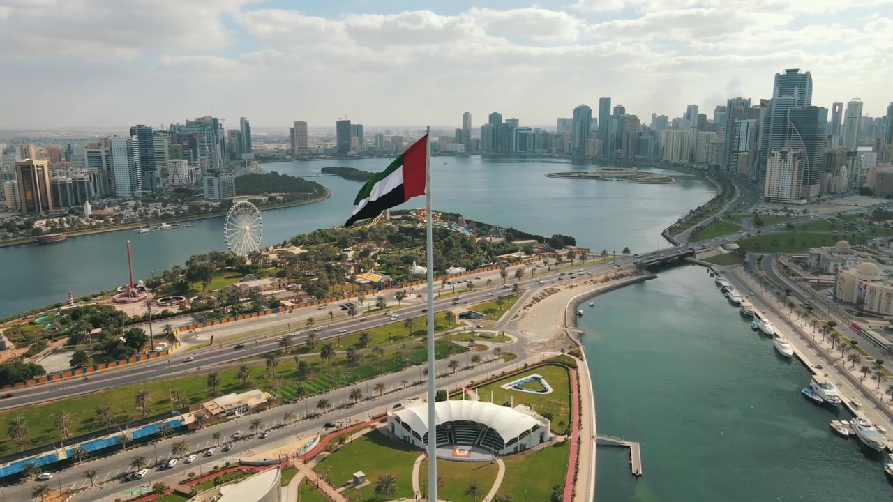 The UAE flag waves prominently over Sharjah, symbolizing national pride.