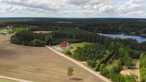 aerial view of a small, red-roofed house in a rural area of borowy młyn in kashubia,pomeranian voivodeship, poland