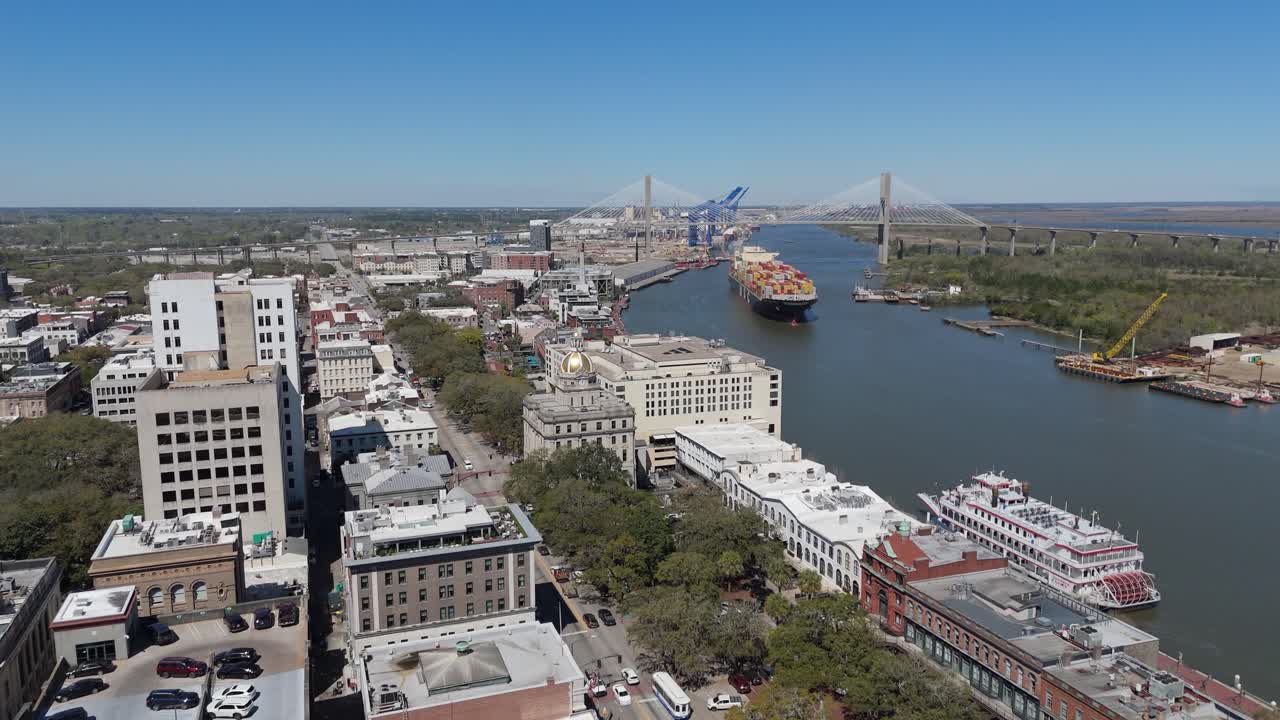 Aerial shot pushing in on Savannah City Hall and The North Historic District with a cargo ship in the background.