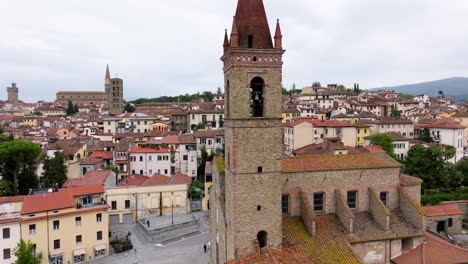 drone orbiting on ancient campanile in arezzo downtown, tuscany, italy