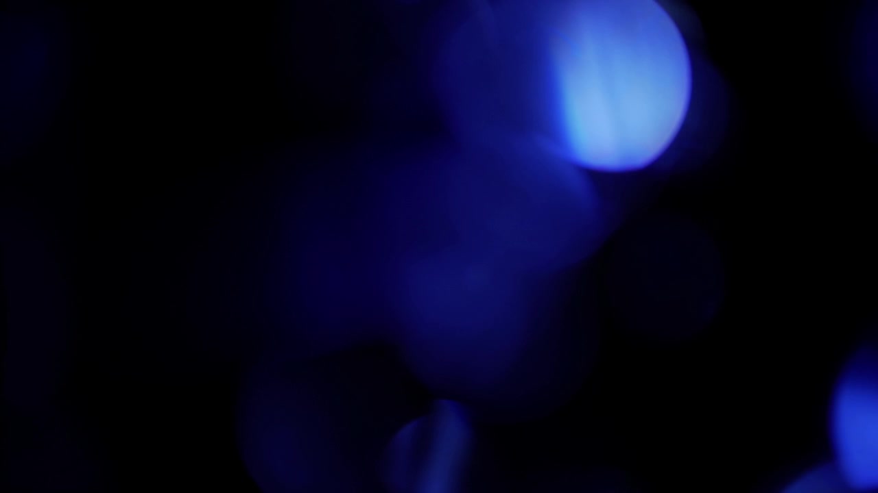 Fughe di luce blu astratte e bokeh su sfondo nero