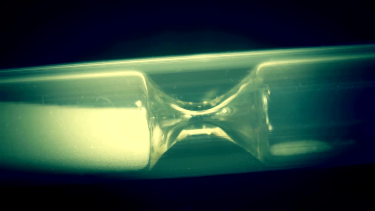 모래시계는 바닥에 모래와 함께 누워 있습니다.