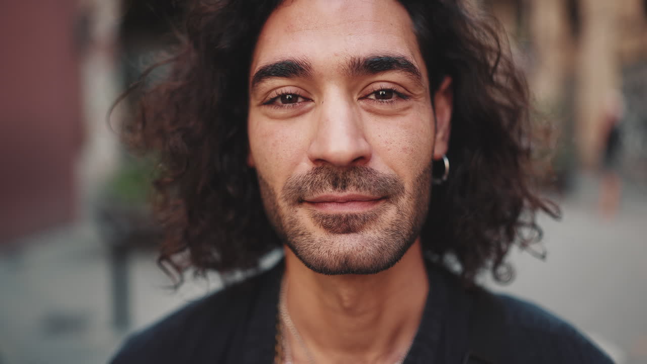 Close-up portrait of a smiling man with curly hair