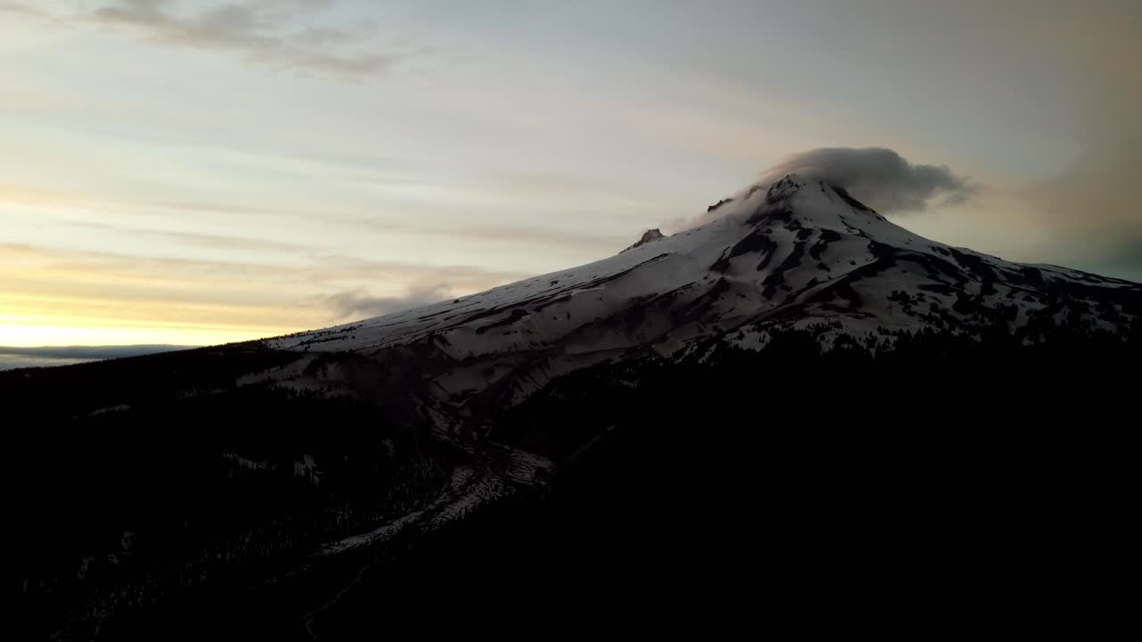 US, Oregon, Mt Hood, , 2025-05-10 - Drone view of Mt Hood in northern Oregon at sunset with clouds curling over the peak of the mountain in the Spring.