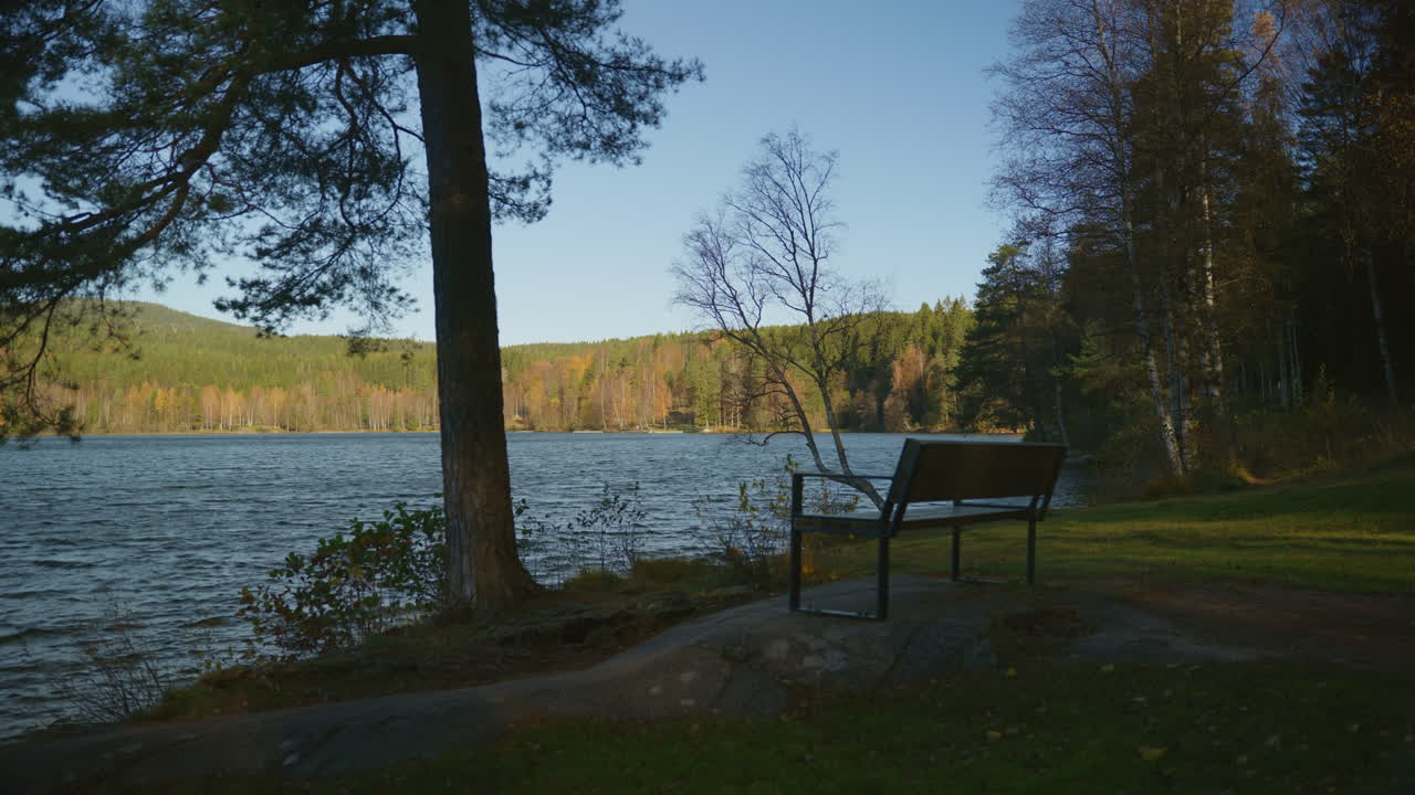 Wide shot of a lonely bench looking out to the lake in Oslo, Norway