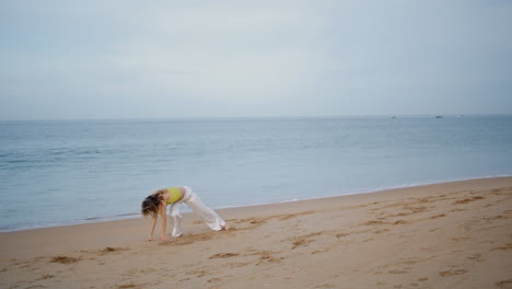 professional artist dancing modern choreography on beach. flexible woman dancer