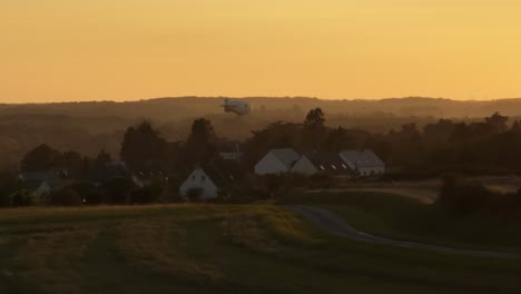 morning skies over a small village in france an airship taking off