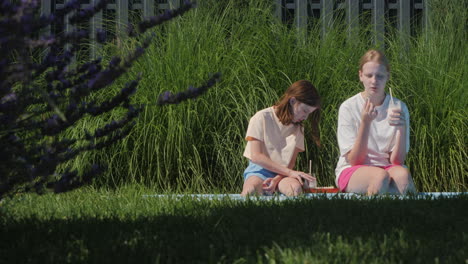 two girls having a picnic by the pool