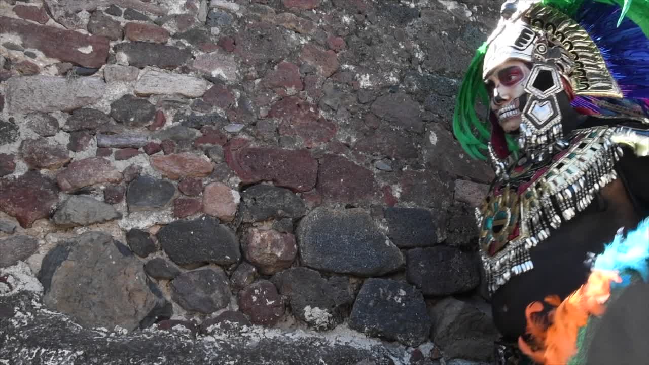 guerrero azteca caminando en pirámide con plumas de colores