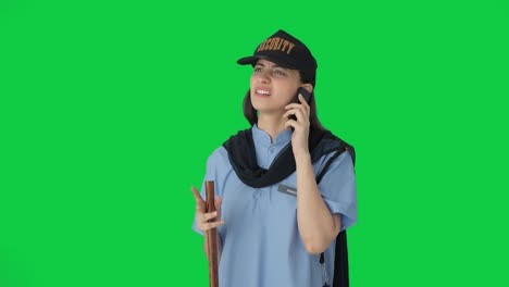 Confused-Indian-female-security-guard-talking-to-someone-on-call-Green-screen