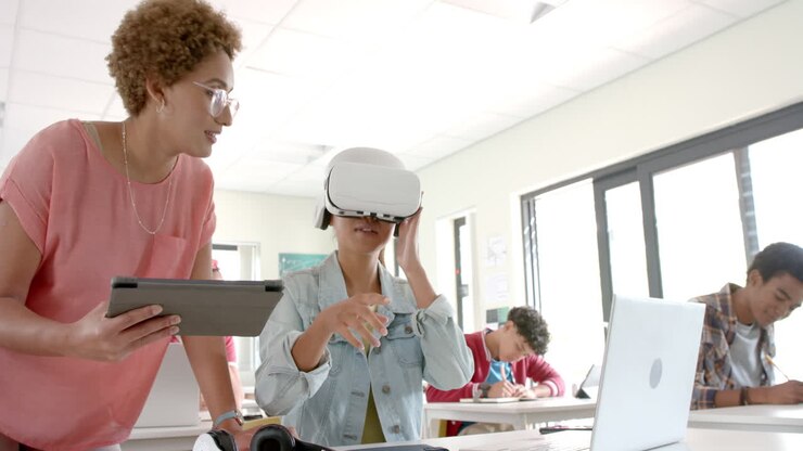 Using VR headset, student interacting with teacher holding tablet in high school