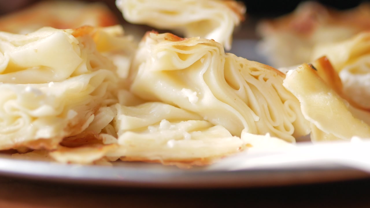 Close-Up of a Fork Picking Up a Piece of Delicious Cheese Burek