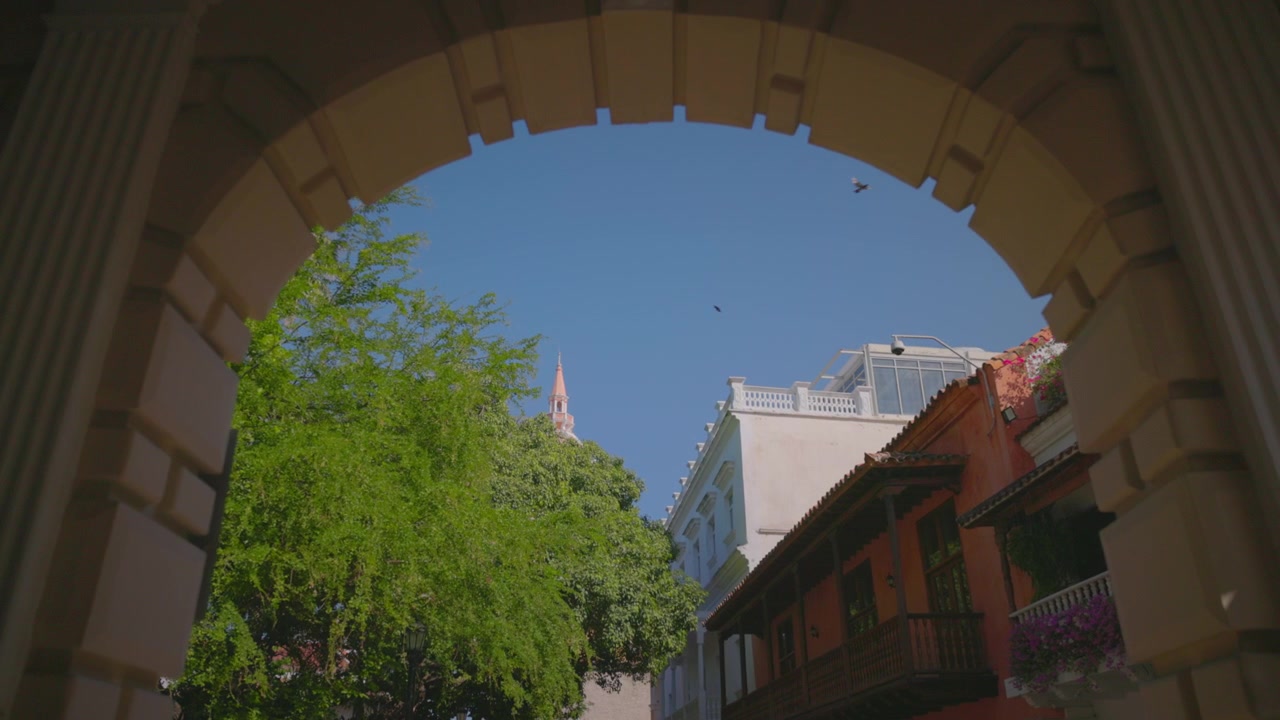 Carrellata indietro per rivelare la Cattedrale di Cartagena incorniciata da un arco in pietra, Colombia.