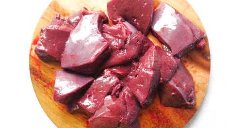 raw sliced liver on wooden cutting board