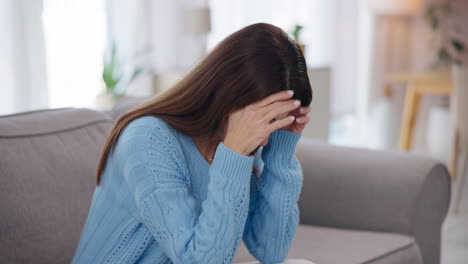 woman sitting on a couch, looking sad and depressed