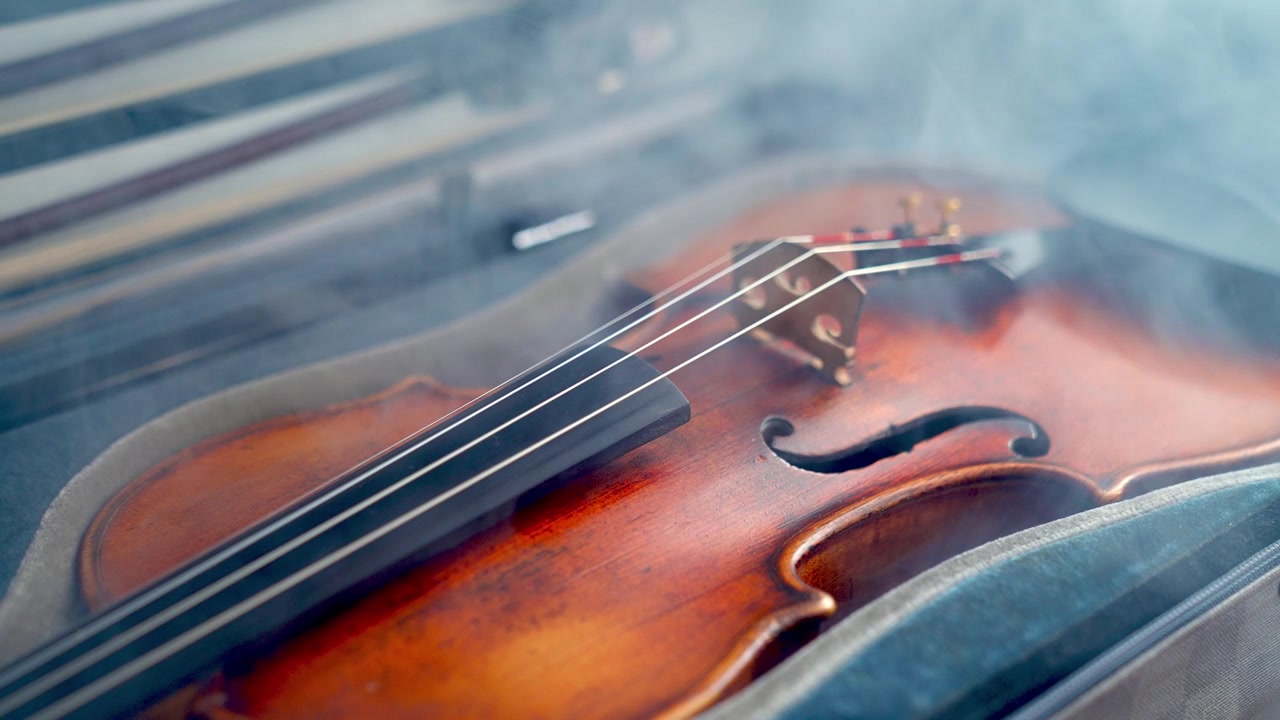 Primo piano drammatico di un violino nella sua custodia con fumo