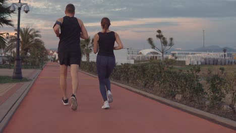 couple running in park at sunset