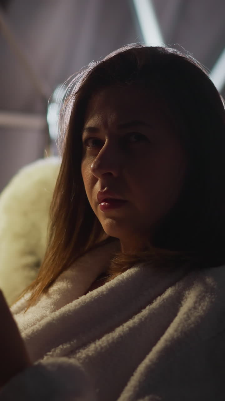 mujer pensativa de mal humor bostezando mirando lejos en la terraza transparente con iluminación apagada. señora frustrada se siente deprimida y sola pensando en los problemas