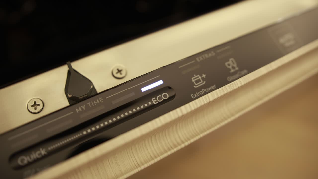 fotografía de cerca de un hombre colocando el lavador de platos en el modo eco y seleccionando el modo de alimentación adicional y cuidado del vidrio