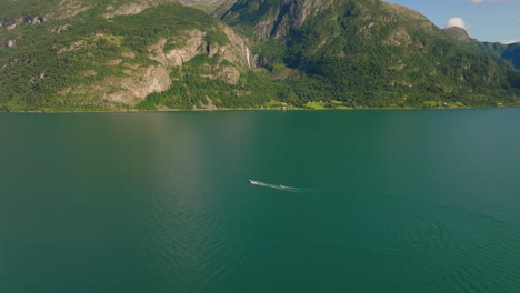 drone orbita alrededor de lancha de velocidad tirando esquiador de agua en lustra fiordo fiordo noruega