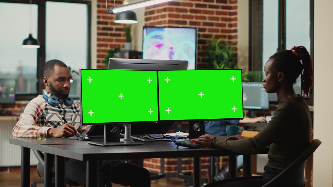 African american woman using greenscreen display on monitors