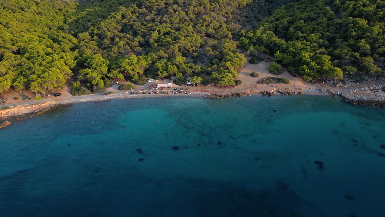 Drone slowly tilting up while flying sideways over beach with ocean on island